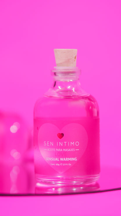 Aceite para masajes Sensual Warming Love Sen Íntimo - foto publicitaria frasco fondo fucsia